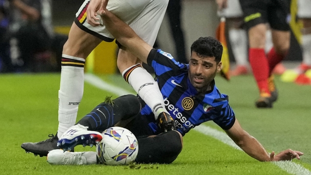 Inter Milan's Mehdi Taremi, right, duels for the ball with Lecce's Federico Baschirotto during a Serie A soccer match between Inter Milan and Lecce, at the San Siro stadium in Milan, Italy, Saturday, Aug. 24, 2024. (AP Photo/Luca Bruno)