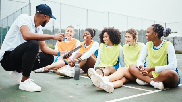 Netball strategy, happy sports team and coach planning game plan, teamwork collaboration or explain competition idea. Coaching athlete, teaching or talking group of people listen to fitness challenge