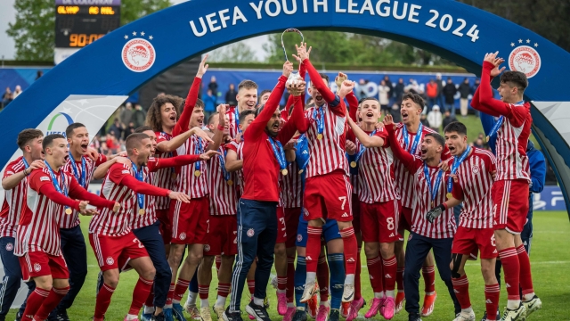 TOPSHOT - Olympiacos' players celebrate with the trophy after wining the UEFA Youth League final fooball match between Olympiacos and AC Milan at Colovray Sport Center in Nyon, on April 22, 2024. (Photo by Fabrice COFFRINI / AFP)