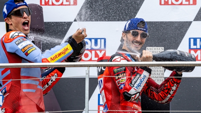 epa11464863 Winner Ducati Lenovo rider Francesco Bagnaia of Italy (R) and second placed Gresini Racing rider Marc Marquez of Spain (L) celebrate on podium after the MotoGP race of the Motorcycling Grand Prix of Germany, at the Sachsenring racetrack in Hohenstein-Ernstthal, Germany, 07 July 2024.  EPA/MARTIN DIVISEK