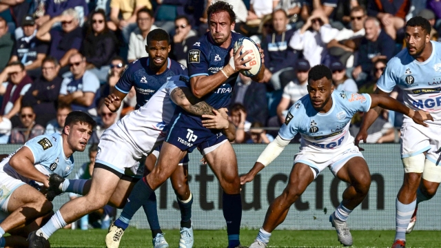 Montpelliers French full back Julien Tisseron (C) is tackled as he runs with the ball during the French Top14 rugby union match between Aviron Bayonnais (Bayonne) and Montpellier Herault rugby at the Stade Jean Dauger in Bayonne, south-western France on September 28, 2024. (Photo by Philippe LOPEZ / AFP)