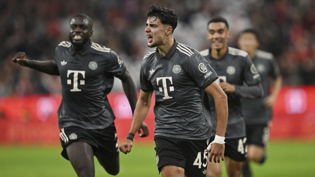 Munich's Aleksandar Pavlovic, center, celebrates with Dayot Upamecano, left, and Jamal Musiala after scoring, during the German Bundesliga soccer match between Bayern Munich and Leverkusen at the Allianz Arena in Munich, Germany, Saturday, Sept. 28, 2024. (Sven Hoppe/dpa via AP)