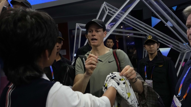 Jannick Sinner of Italy autographs for fans after defeating Roman Safiullin of Russia during the China Open tennis tournament held at the National Tennis Center in Beijing, Saturday, Sept. 28, 2024. (AP Photo/Ng Han Guan)