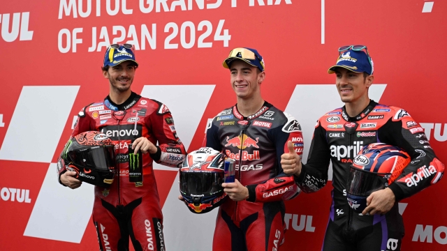 MogoGP class pole sitter Red Bull GASGAS Tech3 rider Pedro Acosta of Spain (C) poses with Ducati Lenovo Team rider Francesco Bagnaia of Italy (L) and Aprilia Racing rider Maverick Vinales of Spain (R) at the parc ferme after the qualifying session of MotoGP Japanese Grand Prix at the Mobility Resort Motegi in Motegi, Tochigi prefecture on October 5, 2024. (Photo by Toshifumi KITAMURA / AFP)