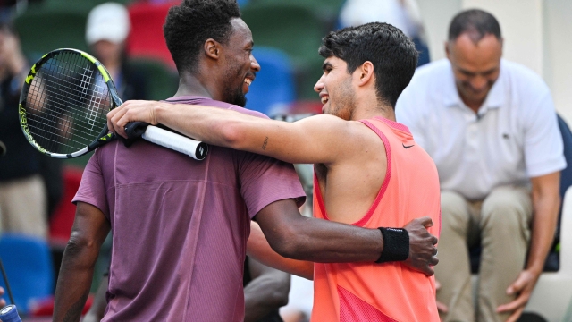 Spain's Carlos Alcaraz (R) shakes hands with France's Gael Monfils at the net following their men's singles match at the Shanghai Masters tennis tournament in Shanghai on October 9, 2024. (Photo by HECTOR RETAMAL / AFP)