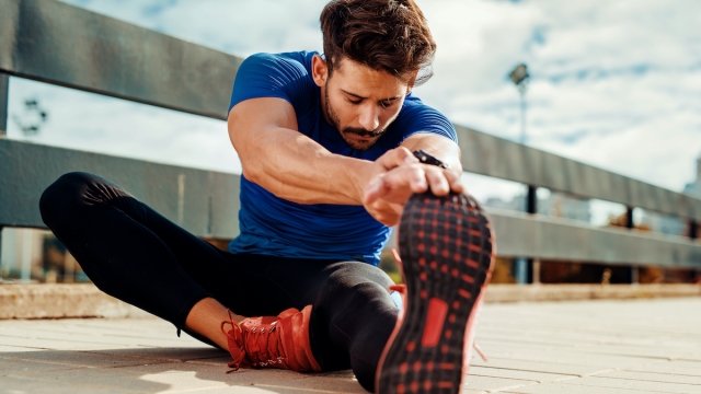 Young male jogger athlete training and doing workout outdoors in city