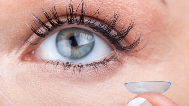 Woman eye with contact lens applying, macro