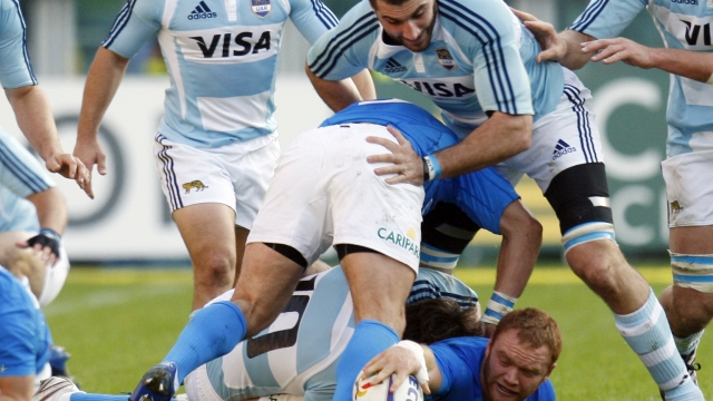 Italy's Gonzalo Garcia, on the pitch, grabs the ball while Argentina's Juan Martin Fernandez Lobbe is above him during the International rugby match between Italy and Argentina, at the Olympic stadium in Turin, Italy, Saturday, Nov.15, 2008. (AP Photo/Luca Bruno)