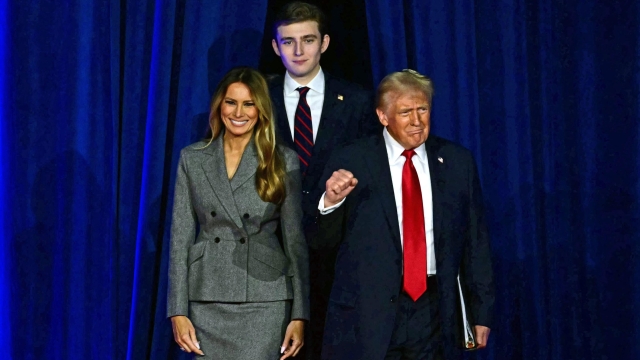 TOPSHOT - Former US President and Republican presidential candidate Donald Trump (R) arrives for  an election night event alongside former US First Lady Melania Trump and his son Barron Trump at the West Palm Beach Convention Center in West Palm Beach, Florida, on November 6, 2024. (Photo by Jim WATSON / AFP)