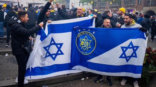 Supporters of Maccabi Tel Aviv hold flags at Dam square ahead of the Europa League football match between Ajax and Maccabi Tel Aviv, in Amsterdam on November 7, 2024. (Photo by Jeroen Jumelet / ANP / AFP) / Netherlands OUT