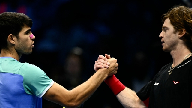 Spain's Carlos Alcaraz shakes hand with Russia's Andrey Rublev after winning his match the ATP Finals tennis tournament in Turin on November 13, 2024. (Photo by Marco BERTORELLO / AFP)