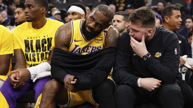 Los Angeles Lakers guard Luka Doncic, right, talks to forward LeBron James on the bench before an NBA basketball game against the Los Angeles Clippers, Tuesday, Feb. 4, 2025, in Inglewood, Calif. (AP Photo/Kevork Djansezian)