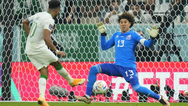 Saudi Arabia's Salem Al-Dawsari scores a goal against Mexico's goalkeeper Guillermo Ochoa during the World Cup group C soccer match between Saudi Arabia and Mexico, at the Lusail Stadium in Lusail, Qatar, Wednesday, Nov. 30, 2022. (AP Photo/Julio Cortez)