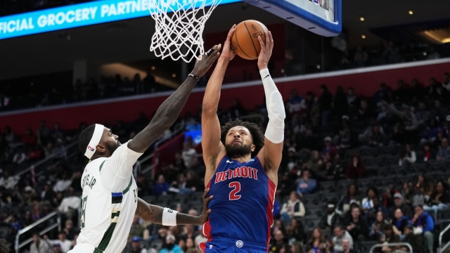 Detroit Pistons guard Cade Cunningham, right, dunks against Milwaukee Bucks forward Bobby Portis, left, during the second half of an NBA basketball game Saturday, Dec. 6, 2025, in Detroit. (AP Photo/Ryan Sun)