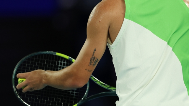  A detailed view of the US Open themed tattoo on the left arm of Carlos Alcaraz of Spain, seen as he prepares to serve against Adam Walton of Australia during the Men's Singles First Round match on day one of the 2026 Australian Open at Melbourne Park on January 18, 2026 in Melbourne, Australia. (Photo by Clive Brunskill/Getty Images)
