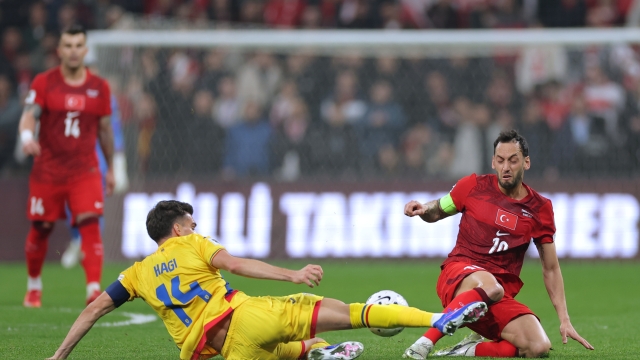 Turkey's Hakan Calhanoglu, right, vies for the ball with Romania's Ianis Hagi during the 2026 World Cup playoff semifinal soccer match between Turkey and Romania, in Istanbul, Turkey, Thursday, March 26, 2026. (AP Photo)