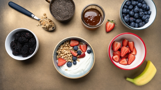Breakfast ingredients and yogurt bowl with fresh berries top view