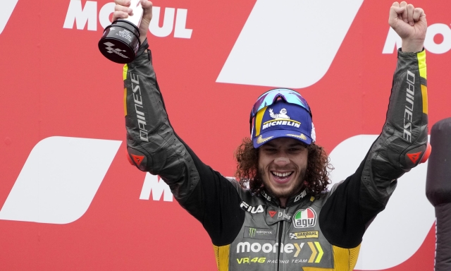 Second placed Italian rider Marco Bezzecchi of the Mooney VR46 Racing Team celebrates with trophy on the podium after the MotoGP race at the Dutch Grand Prix in Assen, northern Netherlands, Sunday, June 26, 2022. (AP Photo/Peter Dejong)