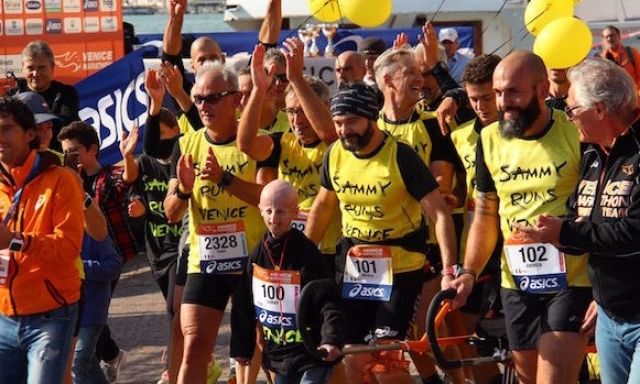 Sammy, fondatore dell’associazione italiana Progeria, all'arrivo della Venice Marathon tira la Joelette.