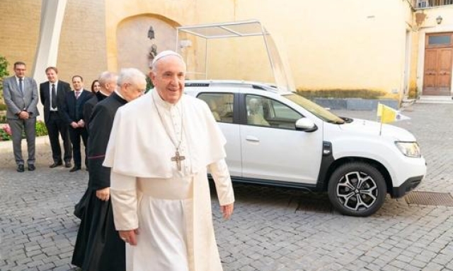 Papa Francesco vicino alla Dacia Duster in versione Papamobile