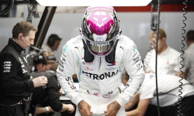 Lewis Hamilton, 35anni, sta per calarsi nell’abitacolo della sua W11 durante di test del Montmelò, lo scorso febbraio. AP