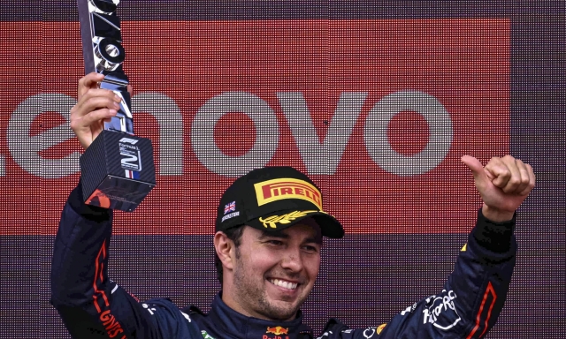 epa10050074 Second placed Mexican Formula One driver Sergio Perez of Red Bull Racing celebrates on the podium after the Formula One Grand Prix of Britain at the Silverstone Circuit, Silverstone, Britain, 03 July 2022.  EPA/CHRISTIAN BRUNA