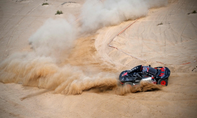 Audi's hybrid Spanish drivers Carlos Sainz and co-driver Lucas Cruz compete during the prologue of the Dakar 2023 by the Red Sea in Yanbu, Saudi Arabia, on December 31, 2022. - Swedish driver Mattias Ekstrom and his co-driver Emil Bergkvist of Sweden won the prologue ahead of French driver Sebastien Loeb and Belgian co-driver Fabian Lurquin. (Photo by FRANCK FIFE / AFP)