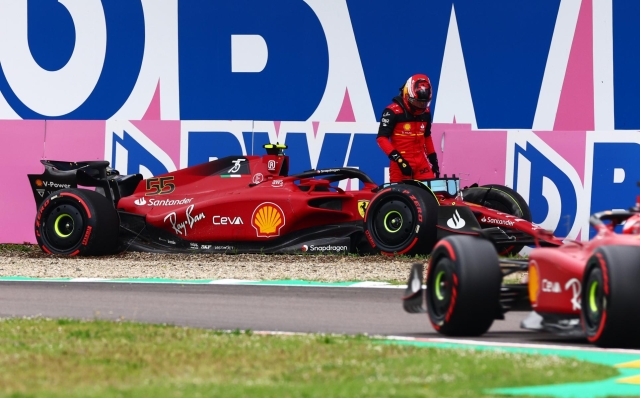 IMOLA, ITALY - APRIL 22: Carlos Sainz of Spain and Ferrari looks on after crashing his car as Charles Leclerc of Monaco driving (16) the Ferrari F1-75 passes him during qualifying ahead of the F1 Grand Prix of Emilia Romagna at Autodromo Enzo e Dino Ferrari on April 22, 2022 in Imola, Italy. (Photo by Mark Thompson/Getty Images)
