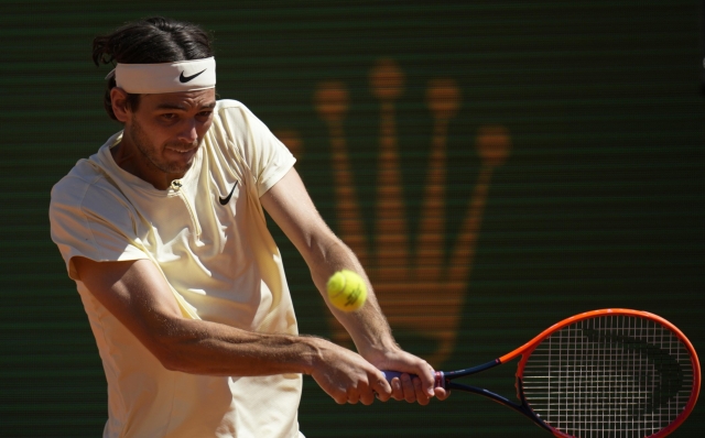 Taylor Fritz, of the United States, returns with a backhand to Stefanos Tsitsipas, of Greece, during their Monte Carlo Tennis Masters quarterfinals match in Monaco, Friday, April 14, 2023. (AP Photo/Daniel Cole)