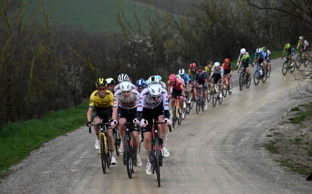 US Sepp Kuss (L), team Visma and Slovenian Tadej Pogacar (2ndL), team UAE lead the race during the 18th one-day classic 'Strade Bianche' (White Roads) cycling race between Siena and Siena, Tuscany, on March 2, 2024. (Photo by Marco BERTORELLO / AFP)