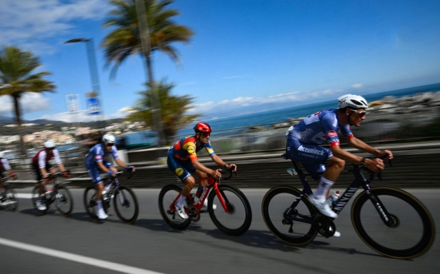 The pack rides along the coastline, during the 115th Milan-SanRemo one-day classic cycling race, between Pavia and SanRemo, on March 16, 2024. (Photo by Marco BERTORELLO / AFP)