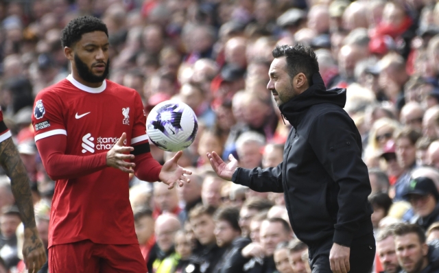 Brighton's head coach Roberto De Zerbi, right, gives the ball to Liverpool's Joe Gomez during the English Premier League soccer match between Liverpool and Brighton and Hove at Anfield Stadium in Liverpool, England, Sunday, March 31, 2024. (AP Photo/Rui Vieira)