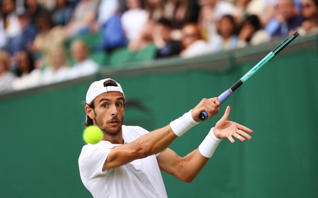 Italy's Lorenzo Musetti returns the ball to France's Giovanni Mpetshi Perricard during their men's singles tennis match on the eighth day of the 2024 Wimbledon Championships at The All England Lawn Tennis and Croquet Club in Wimbledon, southwest London, on July 8, 2024. (Photo by HENRY NICHOLLS / AFP) / RESTRICTED TO EDITORIAL USE