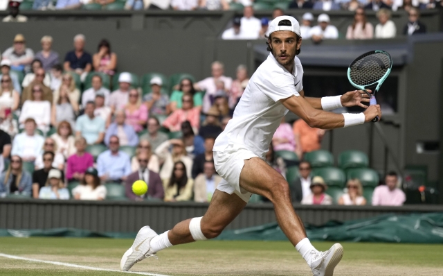 Lorenzo Musetti of Italy plays a backhand Novak Djokovic of Serbia during their semifinal match at the Wimbledon tennis championships in London, Friday, July 12, 2024. (AP Photo/Mosa'ab Elshamy)