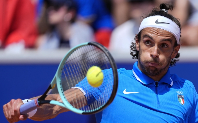 Lorenzo Musetti of Italy returns a backhand shot to Taylor Fritz of the United States during their men's singles third round match, at the 2024 Summer Olympics, Wednesday, July 31, 2024, at the Roland Garros stadium in Paris, France. (AP Photo/Andy Wong)