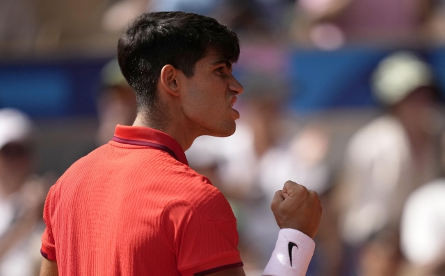 Spain's Carlos Alcaraz clenches his fist as he plays Serbia's Novak Djokovic during the men's singles tennis final at the Roland Garros stadium during the 2024 Summer Olympics, Sunday, Aug. 4, 2024, in Paris, France. (AP Photo/Louise Delmotte)