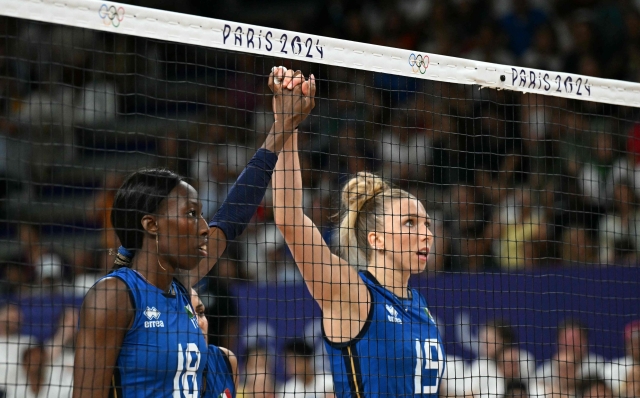 Italy's #18 Paola Ogechi Egonu (L) stands hand in hand with Italy's #19 Sarah Luisa Fahr prior to the volleyball women's quarter-final match between Italy and Serbia during the Paris 2024 Olympic Games at the South Paris Arena 1 in Paris on August 6, 2024. (Photo by PATRICIA DE MELO MOREIRA / AFP)