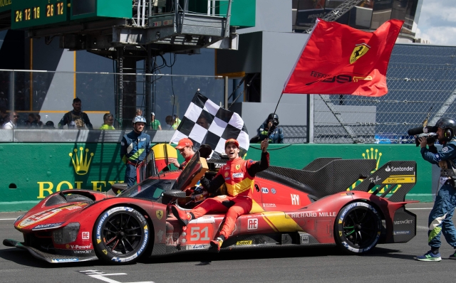 Ferrari N.51 499P Hypercar drivers British James Calado (L) and Italian Antonio Giovinazzi (R) join Italian Alessandro Pier Guidi (car) to celebrate after winning the 24 hours of Le Mans endurance race on June 11, 2023. This year marks the 100th anniversary of the race. (Photo by Fred TANNEAU / AFP)
