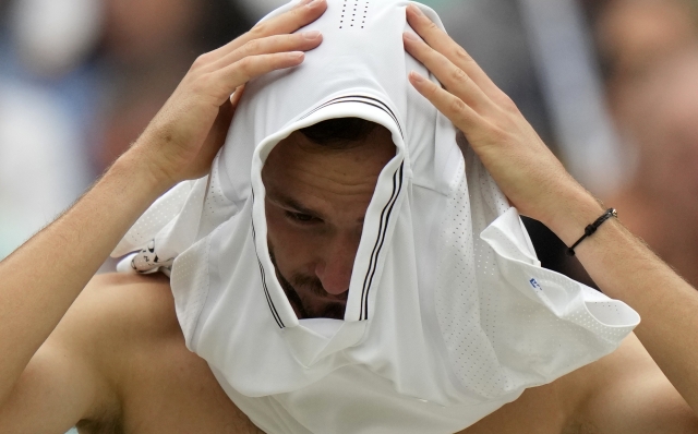 Russia's Daniil Medvedev changes shirts during his men's singles match against Christopher Eubanks of the US on day ten of the Wimbledon tennis championships in London, Wednesday, July 12, 2023. (AP Photo/Alastair Grant)