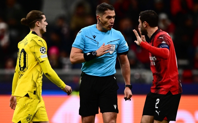 AC Milan's Italian defender #02 Davide Calabria (R) argues with the referee during the UEFA Champions League Group F football match between AC Milan and Borussia Dortmund at the San Siro stadium in Milan on November 28, 2023. (Photo by Marco BERTORELLO / AFP)