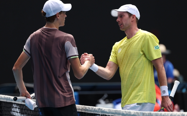 MELBOURNE, AUSTRALIA - JANUARY 14: Jannik Sinner (L)of Italy shakes hands with Botic van de Zandschulp of the Netherlands after winning his round one singles match during day one of the 2024 Australian Open at Melbourne Park on January 14, 2024 in Melbourne, Australia. (Photo by Julian Finney/Getty Images)