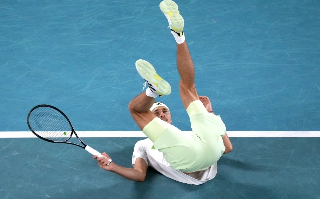 Alexander Zverev of Germany falls during his semifinal against Daniil Medvedev of Russia at the Australian Open tennis championships at Melbourne Park, Melbourne, Australia, Friday, Jan. 26, 2024. (AP Photo/Louise Delmotte)