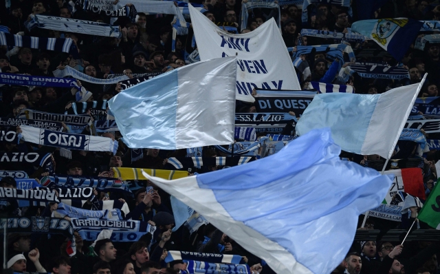 Lazio's supporters wave flags before the UEFA Champions League last 16 first leg between Lazio and Bayern Munich at the Olympic stadium on February 14, 2024 in Rome. (Photo by Filippo MONTEFORTE / AFP)