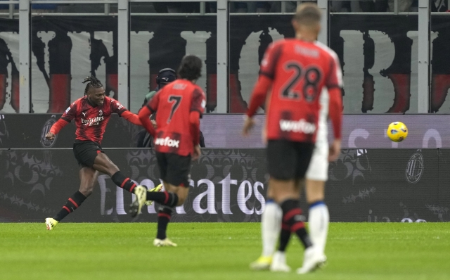 AC Milan's Rafael Leao, left, scores his side's first goal during a Serie A soccer match between AC Milan and Atalanta at the San Siro stadium in Milan, Italy, Sunday, Feb. 25, 2024. (AP Photo/Antonio Calanni)