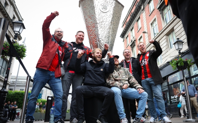 epa11360050 Leverkusen fans pose with a giant replica Europa League trophy ahead of the UEFA Europa League final in Dublin, Ireland, 22 May 2024.  EPA/ADAM VAUGHAN