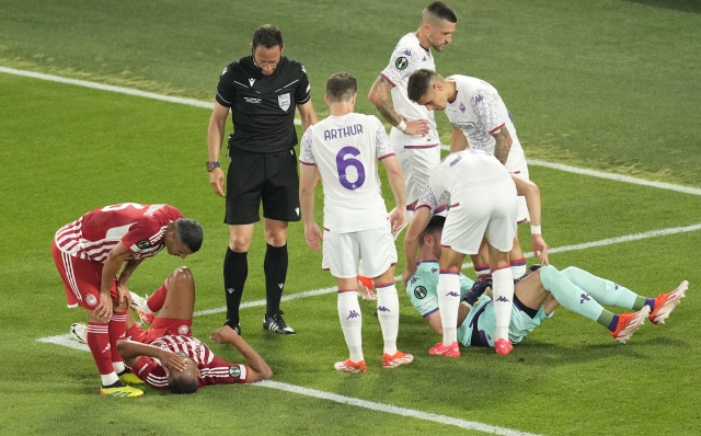 Fiorentina's goalkeeper Pietro Terracciano and Olympiacos' Ayoub El Kaabi are assisted after a clash during the Conference League final soccer match between Olympiacos FC and ACF Fiorentina at OPAP Arena in Athens, Greece, Wednesday, May 29, 2024. (AP Photo/Petros Karadjias)