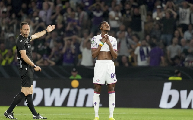 Referee Artur Soares Dias gestures while Fiorentina's Christian Kouame reacts after a missed chance to score during the Conference League final soccer match between Olympiacos FC and ACF Fiorentina at OPAP Arena in Athens, Greece, Wednesday, May 29, 2024. (AP Photo/Petros Giannakouris)