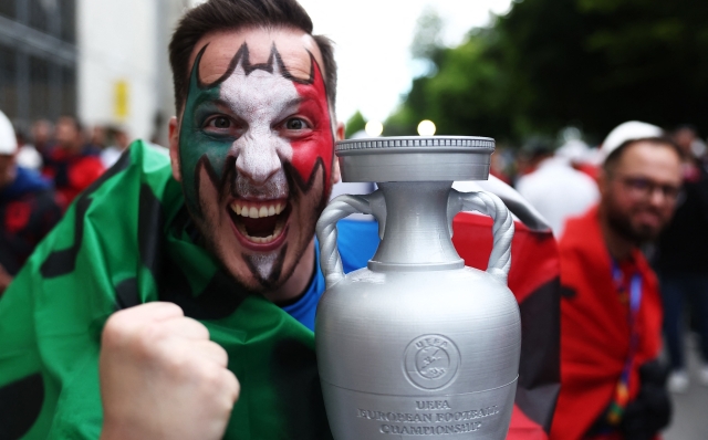 A fan of Italy celebrates with a replica of the UEFA trophy prior the UEFA Euro 2024 Group B football match between Italy and Albania at the BVB Stadion in Dortmund, western Germany, on June 15, 2024. (Photo by FRANCK FIFE / AFP)