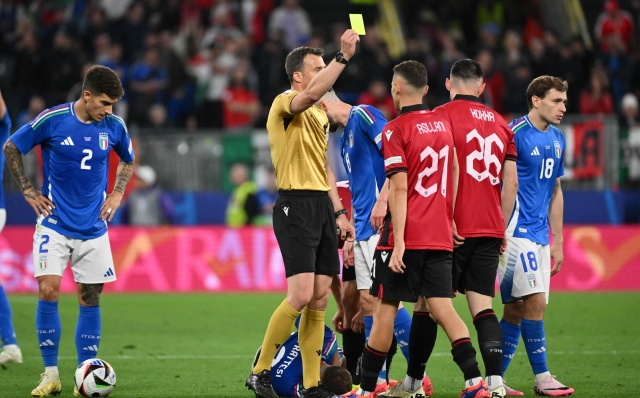 German referee Felix Zwayer gives a yellow card to Albania's forward #26 Arber Hoxha (2nd R) during the UEFA Euro 2024 Group B football match between Italy and Albania at the BVB Stadion in Dortmund on June 15, 2024. (Photo by Alberto PIZZOLI / AFP)
