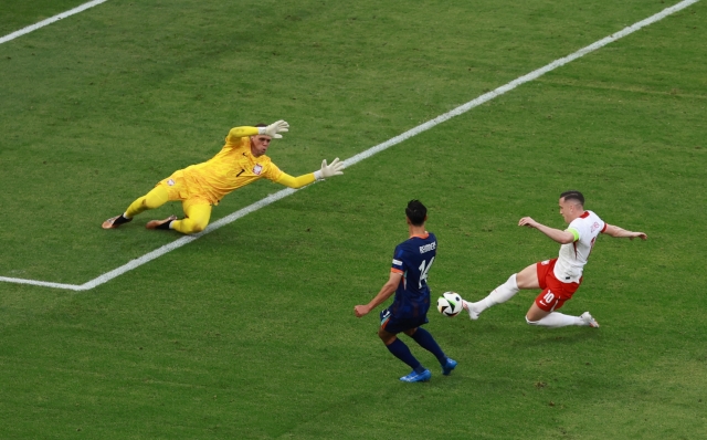 epa11415196 Piotr Zielinski of Poland (R) clears ahead of  Tijjani Reijnders of the Netherlands (C) during the UEFA EURO 2024 group D match between Poland and Netherlands, in Hamburg, Germany, 16 June 2024.  EPA/CLEMENS BILAN